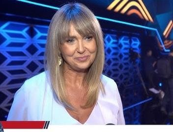 Ewa Wachowicz w eleganckiej stylizacji, uśmiechnięta, symbolizująca jej klasę i profesjonalizm, z delikatnym tłem podkreślającym jej wyrafinowany wizerunek.