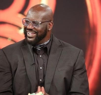 Shaquille O'Neal celebrujący mistrzostwo NBA w koszulce Lakers, otoczony konfetti i kolegami z drużyny.