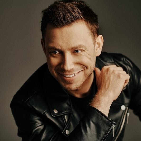 Paweł Jasionowski na scenie podczas koncertu z zespołem Masters, pełen energii.