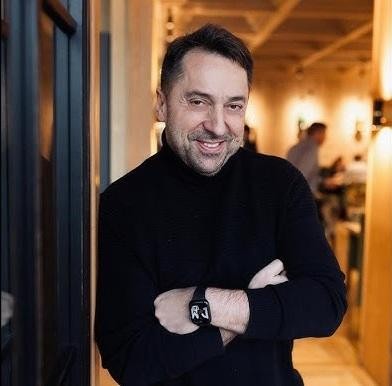 Marcin Miller uśmiechnięty, w zbliżeniu, ukazujący jego optymistyczne i charyzmatyczne oblicze.
