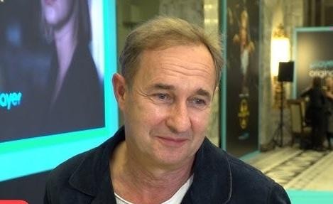 Marek Kalita na scenie teatralnej, w trakcie dynamicznego występu aktorskiego, z ekspresyjną mimiką.